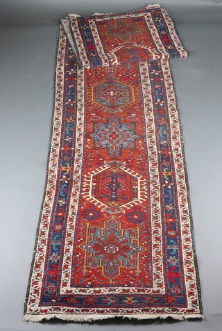 A brown, white and blue ground Caucasian runner with 9 medallions to the centre within a multi row border 447cm x 95cm w 