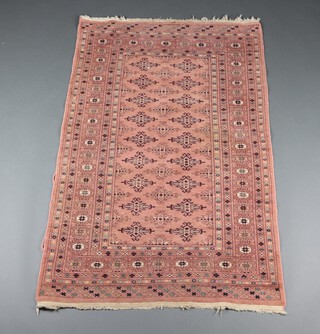 A pink and black ground Bokhara rug with 28 stylised medallions to the centre within a multi row border 152cm x 97cm 
