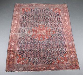 A blue and red ground North Persian floral patterned rug with central medallion 188cm x 134cm 