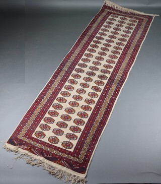 A white and red ground Bokhara runner with 71 octagons to the centre 209cm x 93cm 