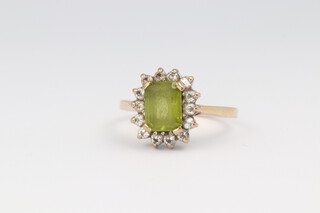 A 9ct yellow gold peridot and diamond ring, the centre stone 1ct, the brilliant cut diamonds 0.14ct, size n 1/2, 3 grams