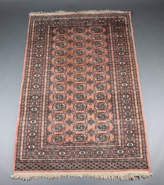 A pink and white ground Bokhara rug with 60 stylised medallions within a multi row border 179cm x 130cm 