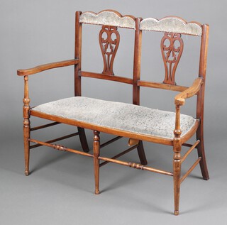 An Edwardian mahogany double chair back settee, raised on turned supports 93cm h x 111cm w x 49cm d 