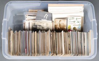 A collection of postcards and black and white photographs etc, contained in a plastic box