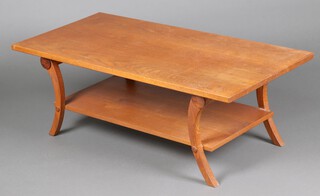 A rectangular 2 tier oak occasional table, on outswept supports 43cm h x 125cm w x 57cm d
