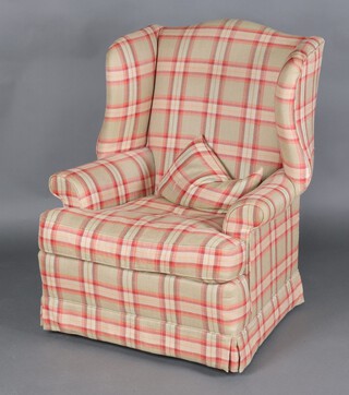 A winged armchair upholstered in checked material, raised on bun feet 105cm h x 76cm w x 72cm d 