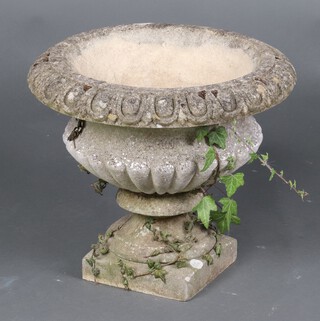 A well weathered circular concrete garden urn with lobed body, on a square base 38cm h x 47cm diam. (in 2 sections)