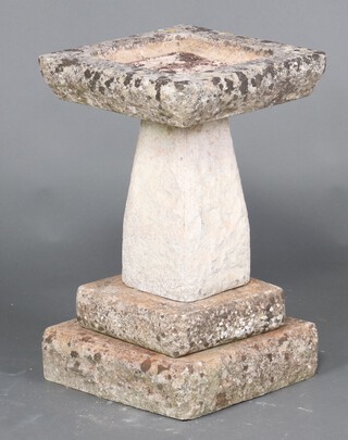 A well weathered square concrete garden  bird bath, raised on a column and stepped base 65cm h x 39cm (in 4 sections)