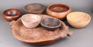 A circular wooden salting style tray and 6 other wooden bowls 