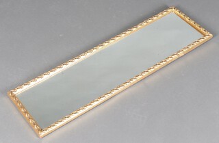 A rectangular plate mirror contained in a decorative gilt frame 103cm x 29cm 