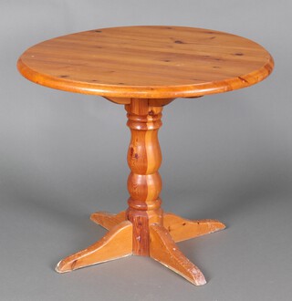 A circular pine pedestal table raised on pillar and quatrepartite support 76cm h x 90cm d