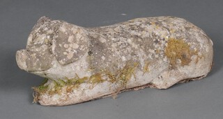 A concrete figure of a reclining pig 18cm h x 46cm w x 22cm d