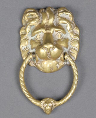A brass door knocker in the form of a lions mask