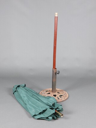 A green garden parasol together with a circular pierced cast iron garden parasol stand 44cm h x 45cm d
