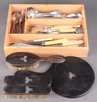 A small quantity of silver plated cutlery and an ebonised four piece dressing table set