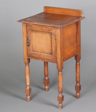 A 1920's oak bedside cabinet with raised back, raised on turned supports 80cm h x 45cm w x 39cm (top loose) 