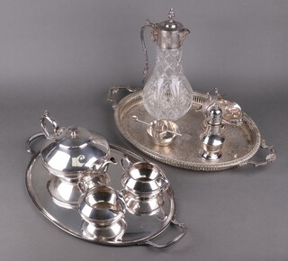 A glass ewer with silver plated mounts, two silver plated twin handled trays and a small quantity of silver plated items