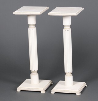 A pair of white painted square pedestals, raised on a fluted column 68cm h x 24cm 
