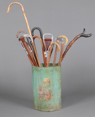 A shaped pressed metal stick stand and a collection of walking sticks 