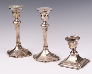 A pair of weighted silver candlesticks Birmingham 1954, maker Denton and Down, 18cm, together with a squat weighted silver candlestick on a square base Birmingham 1944 (sconce is loose)  