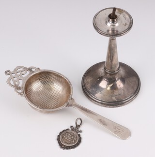 A silver spirit  table lighter Birmingham 1915 11cm, a silver tea strainer Birmingham 1925 (handle soldered) together with a silver shooting medallion Birmingham 1934, weighable silver 50 grams 