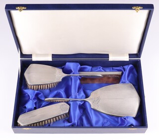 A 4 piece silver backed dressing table set Birmingham 1988, 89 and 1990, comprising hair brush, hand mirror, comb and clothes brush, contained in a presentation case 