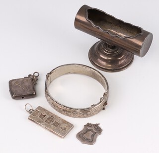 A Sterling silver mounted rectangular tooth pick stand, a 1977 Silver Jubilee ingot pendant, an engraved silver bracelet (dented), a silver pendant marked "Baby" (dented) and a silver fob (a/f), 98 grams 