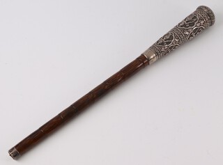 An Eastern embossed white metal parasol terminal decorated figures 