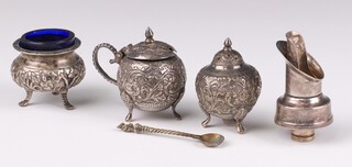 An Eastern embossed 3 piece condiment set comprising mustard pot, salt and pepper together with a spirit pourer 