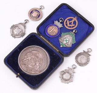 A Masonic pierced 9ct gold pendant decorated square and compasses 2.35 grams, 6 various silver watch chain fobs 48grams and a Portsmouth Educational authority medallion 