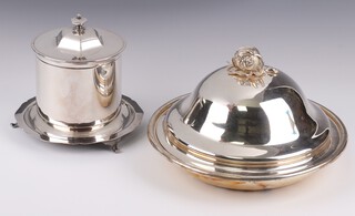 A silver plated biscuit barrel on panel supports 12cm h x 16cm diam. and a silver plated dish and cover with armorial decoration and pomegranate finial 10cm x 20cm diam. 