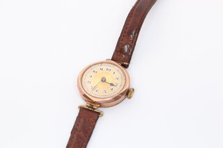 A lady's wristwatch contained in a 9ct yellow gold case on a brown leather strap
