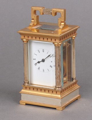 A 20th Century English carriage timepiece with 4cm enamelled dial, Roman numerals, contained in a gilt metal and silver case with reeded columns to the sides 9cm h x 6cm w x 5cm d, complete with key