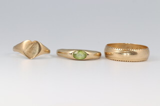 A 9ct yellow gold signet ring size H 1/2, a ditto wedding band size N and a peridot set ring size J, gross weight 5 grams 