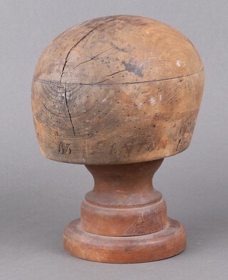 A 19th Century wooden hat block, the base marked 55 Liton, raised on an associated turned wooden base 20cm x 17cm x 15cm 