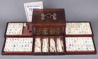 A Mahjong set comprising 145 bamboo and bone counters, together with numerous counting sticks, contained in a wooden case 
