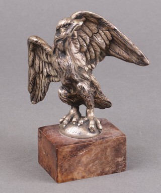 A nickel plated paperweight in the form of an Eagle raised on a square marble base, 12 cm h