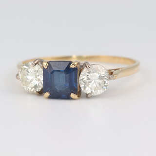 An 18ct yellow gold sapphire and diamond 3 stone ring, the centre princess cut sapphire approx. 1ct, the 2 brilliant cut diamonds each approx. 0.5ct, size T, 3 grams 