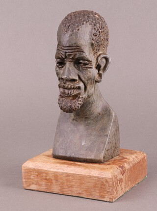 An African carved hardstone head and shoulders portrait bust of a kneeling gentleman on a wooden base 19cm 