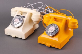 A 1950's ivory coloured dial telephone marked 164-52 (crack to back) together with a similar yellow telephone 