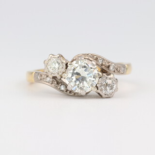 An 18ct yellow and white gold 3 stone diamond engagement ring set in a twist mount with brilliant cut diamonds to the shoulders, approx. 1.08ct in total, size L 1/2, 4.35 grams