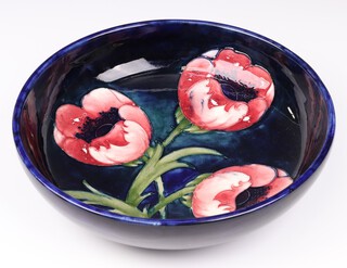 A Walter Moorcroft Poppy pattern bowl on a blue ground, impressed marks and signed, circa 1950's, 30cm diam. 