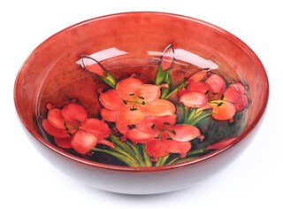 A Walter Moorcroft Freesia pattern bowl on a red ground, impressed marks and signed, circa 1934, 27cm diam.