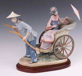 A Lladro figure group of a rickshaw, seated lady and parasol, base impressed 1383, modelled by Salvador Debon 31cm high 