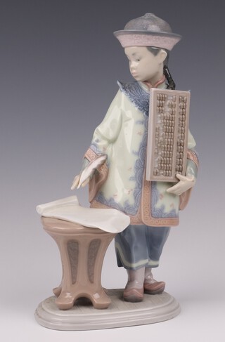 A Lladro figure of a standing Chinese schoolboy with abacus, base impressed G177, by Francisco Polope, 23cm 