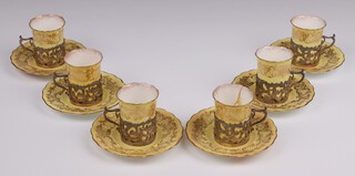 An Edwardian Coalport yellow and gilt coffee service comprising 6 coffee cans and 6 saucers with silver mounts by the Goldsmiths and Silversmiths Co., London 1901
