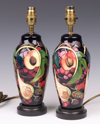 Emma Bossons for Moorcroft, a pair of Queens Choice table lamps raised on circular wooden bases, impressed and painted marks, 24cm 