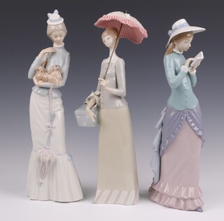 Three Lladro figures, lady with parasol 37cm, lady with book no.5000 36cm and lady with a dog 4893 36cm  numbers of ladies,  boxed 