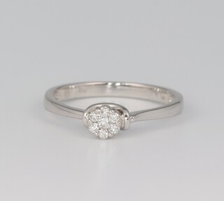 An 18ct white gold 7 stone diamond cluster ring, approx 0.13ct, size O 1/2, 2.6 grams, with original Damas certificate 