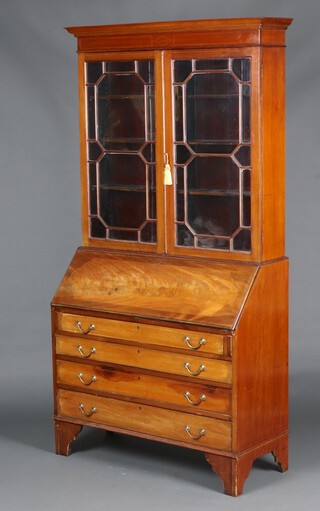 An Edwardian inlaid mahogany bureau bookcase with moulded cornice, fitted shelves enclosed by astragal glazed doors, the base with fall front revealing a well fitted interior with pigeon holes and drawers, above 4 long drawers, raised on bracket feet 207cm h x 106cm w x 44cm d